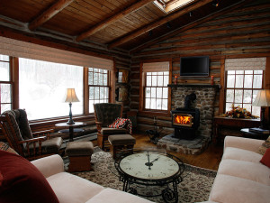 log cabin living room with fire in wood burning stove